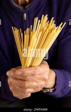 Vecchio che tiene alcuni spaghetti Foto Stock