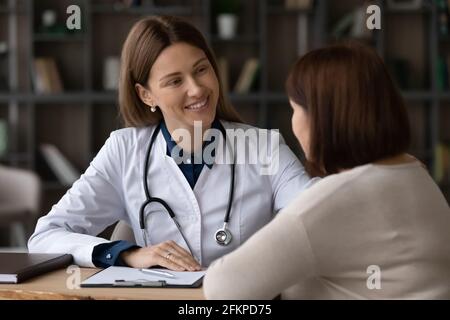 Sorridente dottore femmina sostenere paziente donna anziana Foto Stock