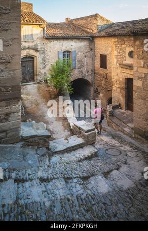 Strada tipica di un villaggio nel sud della Francia, con scale, pendii e un arco Foto Stock