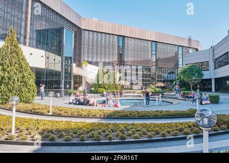 Sochi, Russia - 8 marzo 2020: Il cortile dell'aeroporto della città di Sochi. I passeggeri attendono il loro volo all'aperto tra le piante vicine Foto Stock