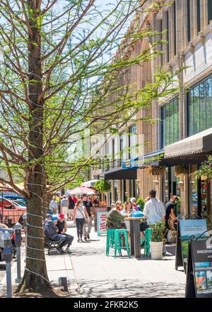 ASHEVILLE, North Carolina, USA-1 MAGGIO 2021: I clienti e gli acquirenti su Page Ave. Nel centro di Asheville, in un caldo, soleggiato giorno di primavera. Maschere antivirus protettive visibili. Foto Stock