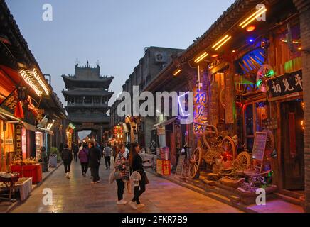 Pingyao nella provincia di Shanxi, Cina: Scena di strada a Pingyao di notte con vista della Torre di Gushi o della Torre della Città e delle luci. Vista serale di Pingyao. Foto Stock