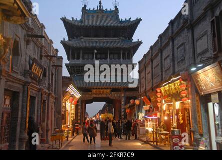 Pingyao nella provincia di Shanxi, Cina: Scena di strada a Pingyao di notte con vista della Torre di Gushi o della Torre della Città e delle luci. Vista serale di Pingyao. Foto Stock