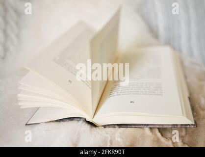 Colpo di closeup di rosa essiccata che posa su un libro aperto Foto Stock