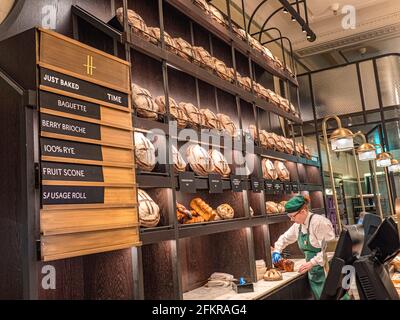 HARRODS PANETTERIA DI LUSSO PANE FRESCO Harrods Food Hall panetteria donna che lavora all'interno 'The Bakery' lusso pane fatto a mano varietà, con marchio ‘H’ con fresche varietà di panetteria a tempo disponibile bacheca, Harrods Food Hall interno 'The Bakery' Harrods Food Hall Store Mall, Brompton Rd, Knightsbridge, Londra SW1X 7XL Foto Stock