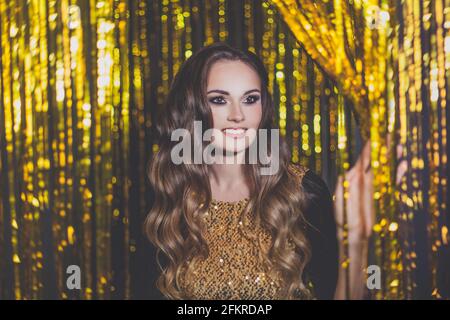 Bella donna celebrità che entra la porta della festa sfondo bokeh dorato Foto Stock