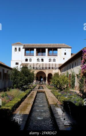 Vista dal cortile con piscina, fontana e giardino. Dettagli sull'architettura islamica all'Alhambra di Granada, Spagna Foto Stock