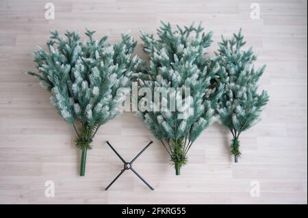 Primo piano di pezzi di albero di Natale artificiale. Il processo di raccolta e decorazione dell'albero per il nuovo anno. Vista dall'alto. Composto Foto Stock