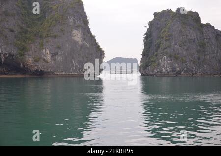 Vista panoramica delle acque verdi, delle formazioni rocciose e delle case galleggianti e delle barche sulla Baia di ha Long in Vietnam Foto Stock