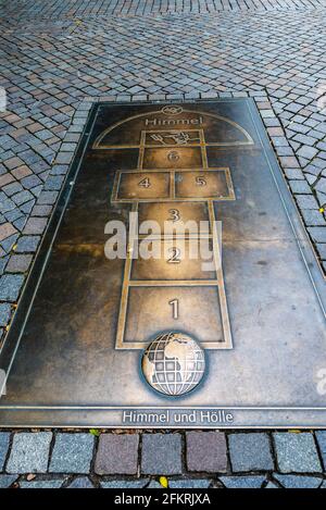 Hamelin, Germania - 20 agosto 2019: Targa sul terreno del gioco Hopscotch Rug (Himmel und Holle) a Hamelin, bassa Sassonia, Germania Foto Stock