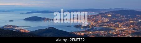 Panoramica di un bellissimo tramonto in città con luci - estuario Vigo, Galizia, Spagna. Foto Stock