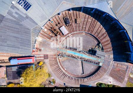 28 aprile 2021, Meclemburgo-Pomerania occidentale, Passerella: Storico giradischi di fronte al deposito locomotivo nel centro di esperienza ferroviaria. (Vista aerea con un drone) il museo è stato chiuso per mesi a causa delle misure di protezione Corona. I visitatori potrebbero ammirare la tecnologia ferroviaria con numerose locomotive a vapore e diesel su un terreno di 40,000 metri quadrati con la storica locomotiva del 1896. La locomotiva celebra un anniversario speciale nel 2021: Avrà 125 anni. Se e in quale forma può essere celebrata dipende dall'ulteriore sviluppo della pandemia. Con Foto Stock