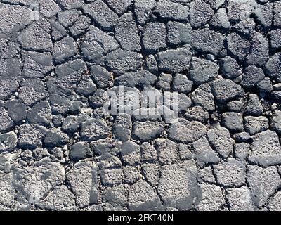 vista dall'alto della strada asfaltata rotta danneggiata la luce solare decadono la siccità Foto Stock