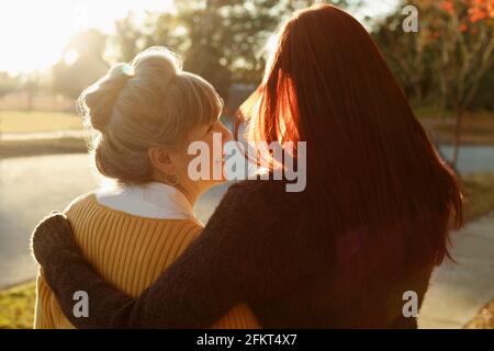 Vista posteriore della donna anziana e della figlia adulta che passeggiano nel parco Foto Stock