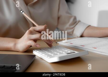 Primo piano della mano di un uomo d'affari che calcola la fattura, il preventivo, il rapporto mensile con calcolatore, concetto di risparmio di contabilità di affari Foto Stock