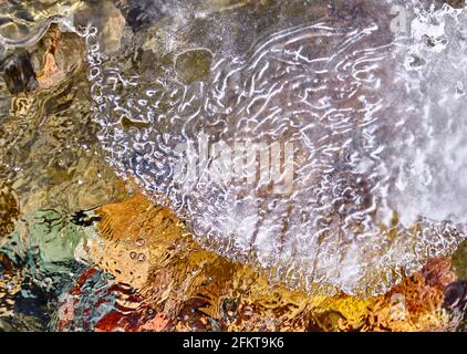 Concetto di bellezza e grandezza della natura: Spettacolare struttura del bordo di ghiaccio che sovrasta l'acqua del fiume di montagna Foto Stock