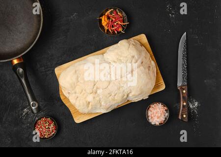 Vista dall'alto della coda di grasso di agnello sul tavolo da cucina con sale e pepe Foto Stock