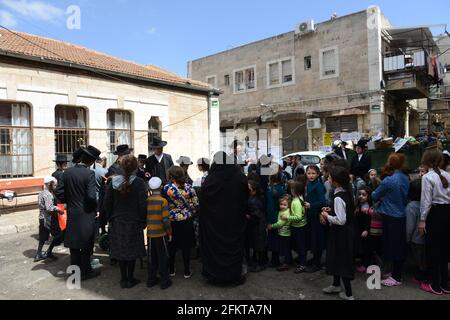 Bambini ebrei ortodossi in attesa di cibo e dolci serviti da un giusto ebreo durante i preparativi della Pasqua a Mea She'arim Gerusalemme. Foto Stock