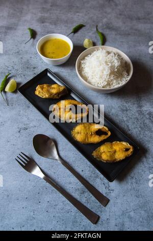 Menu per pranzo in stile bengalese, pesce fritto servito con riso al vapore e legumi. Foto Stock