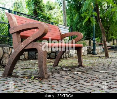 Un vuoto di una panchina nel parco. Foto Stock