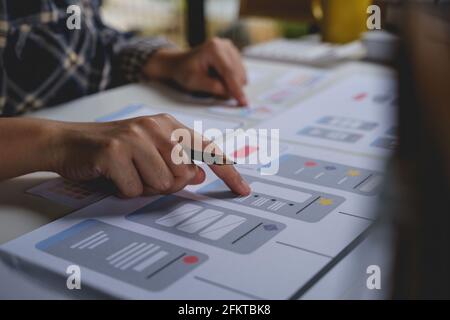 Primo piano dello sviluppatore ux femminile e del progettista ui sull'interfaccia dell'app per telefono cellulare nel salotto di casa.concetto di agenzia di sviluppo digitale creativo. Foto Stock