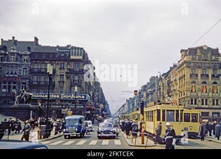 Guardando lungo un trafficato Boulevard Anspach a Place de Bourse, Bruxelles, Belgio c.1958. La strada principale nel centro della città ha sia tram e traffico a motore e i pedoni sono in corsa. I gradini a sinistra conducono alla Borsa di Bruxelle. I tram corrono lungo la strada 56. Il percorso non esiste più e l'intera area è ora pedonale e priva di traffico. Questa immagine proviene da un vecchio lucido a colori Kodak dilettante da 35 mm, una fotografia degli anni '50. Foto Stock