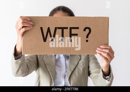 Una donna ha una bandiera con l'iscrizione WTF? davanti a lei. Foto Stock