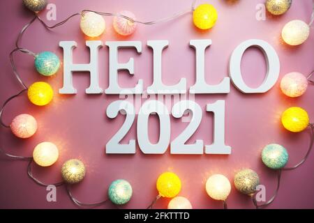 Hello 2021 lettera alfabetica con pallina di cotone decorazione a LED su sfondo rosa Foto Stock