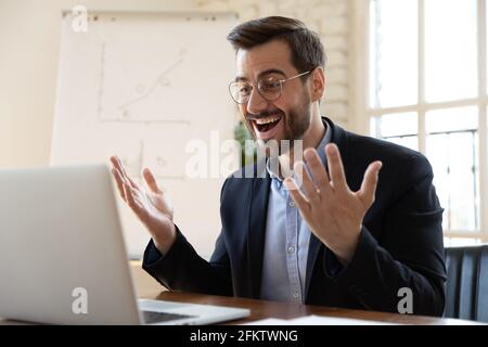 Felice giovane impiegato di sesso maschile celebrare il successo di affari. Foto Stock