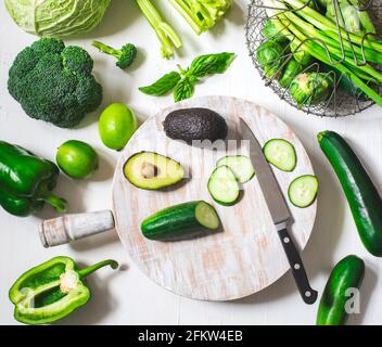 Verdure verdi su una tavola da cucina di legno. Cibo sano, vista dall'alto Foto Stock