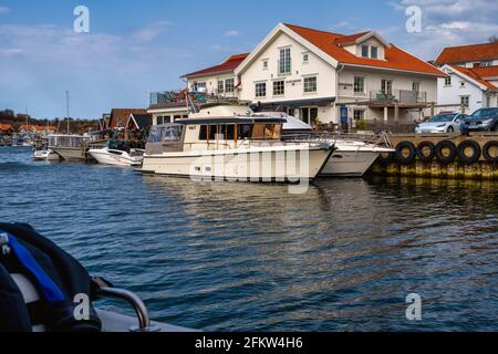 17 aprile 2021 - Hamburgsund, Svezia: Le tradizionali capanne di mare rosso e le barche da pesca sono sostituite da grandi case di fantasia e yacht costosi Foto Stock