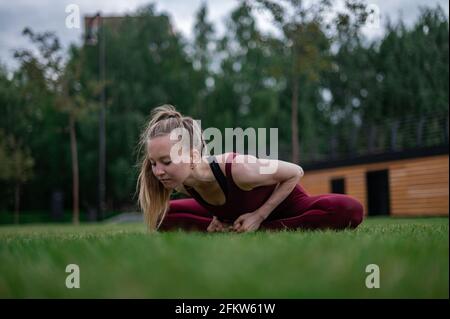 La ragazza pratica yoga e meditazione in città. Foto Stock
