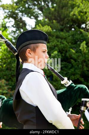 Giovane piper che suona cornamusa a Helensburgh, Scozia Foto Stock