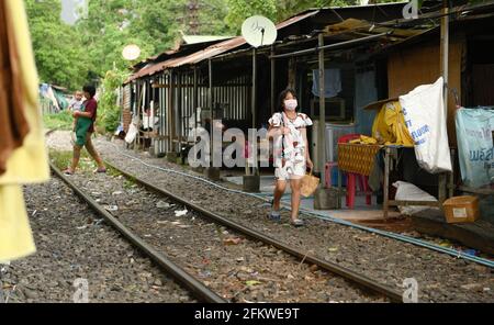 Una donna che indossa una maschera facciale cammina lungo la ferrovia track.Bangkok città abitanti urbani che vivono lungo la linea ferroviaria. La ferrovia di Stato della Thailandia (SRT) viaggia dalla stazione centrale di Bangkok a Hua Lamphong ad est della capitale e si collega a Chachoengsao, 82 km da Bangkok lungo questa linea. (Foto di Paul Lakatos / SOPA Images/Sipa USA) Foto Stock