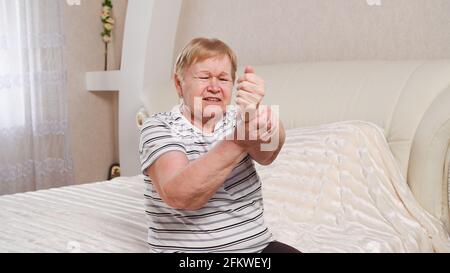 Donna anziana con dolore alle braccia Foto Stock