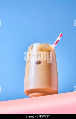 Caffè ghiacciato con latte in calici al tavolo rosa e sfondo blu. Hero View alla moda. Foto Stock