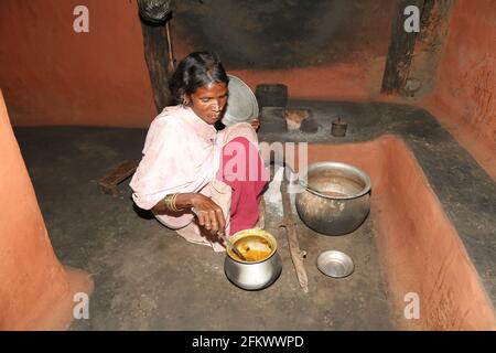 Donna tribale che prepara i suoi pasti giornalieri nella sua cucina al villaggio di Lanjigadh a Odisha, India. TRIBÙ DESIA KONDHA Foto Stock