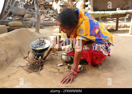 Donna tribale che fa cibo usando il cuore di fango naturale tradizionale. TRIBÙ KOLI. Odasinga Jodum di Cuttack, Odisha, India Foto Stock