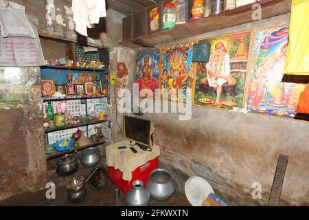 Vista interna del soggiorno della casa. I poster colorati di Dio Indù, Dea sono incollati sulle pareti. TRIBÙ KOLI. Odasinga Jodum di Cuttack, Odisha, India Foto Stock