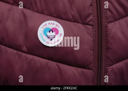 Badge adesivo "i've Had my Covid Vaccination" sulla giacca trapuntata con maroon. Foto Stock