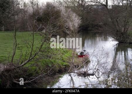 Camminando sulla Ouse Way, Barcombe Mills, Inghilterra, una piccola barca ormeggiata sulla riva Foto Stock