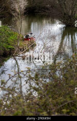 Camminando sulla Ouse Way, Barcombe Mills, Inghilterra, una piccola barca ormeggiata sulla riva Foto Stock