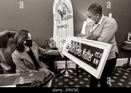 Chief Spokes persona per il Vice Presidente Symone Sanders mostra Vice Presidente Kamala Harris un segno Black Lives Matter via Martedì, 16 febbraio 2021, nel suo Ufficio West Wing della Casa Bianca. Il cartello è un regalo del sindaco della DC Muriel Bowser. (Foto ufficiale della Casa Bianca di Lawrence Jackson) Foto Stock