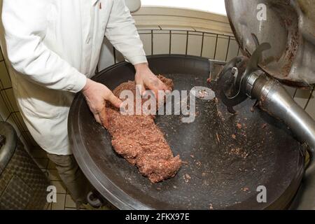 Salsicce, salsiccia massa nel tagliatore Foto Stock