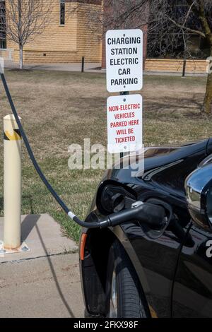 White Bear Lake, Minnesota. Stazione di ricarica per auto elettriche di livello due sui terreni dell'università Century con auto collegata. Foto Stock