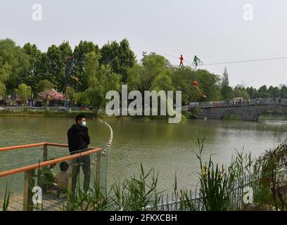 Fuyang, Cina. 04 maggio 2021. Durante la festa del giorno di maggio, gli artisti popolari effettuano la camminata di alta quota tightrope per i turisti nel parco ecologico di Fuyang. Credit: SOPA Images Limited/Alamy Live News Foto Stock