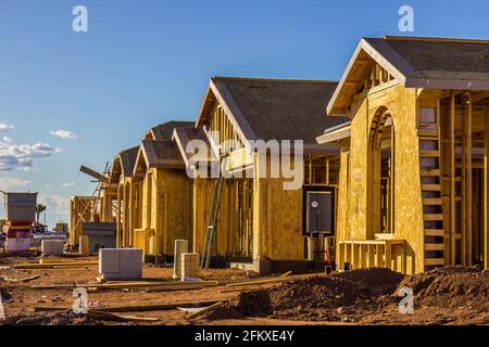 Fila di nuove case in costruzione nel tardo pomeriggio Foto Stock