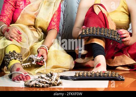 Indiano Classical Girls Kathak Dancer in abito tradizionale o costume Tie Ghungroo Ghungru o Noopura che è UN Anklet musicale Ai piedi dipinto wit Foto Stock