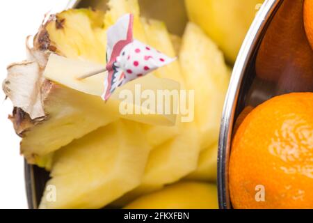 Delizioso ananas a fette con ombrello giocattolo di carta. Scatto macro. La foto può essere utilizzata come sfondo completo. Foto Stock