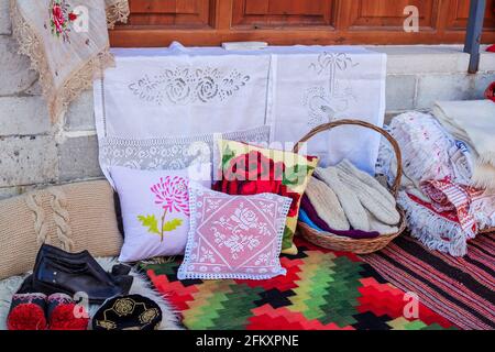 Città di Gjirokaster/Albania - 2 agosto 2020: Tappeti fatti a mano, tovaglie, cuscini ricamati, calze in lana a maglia e scarpe tradizionali in vendita a st Foto Stock